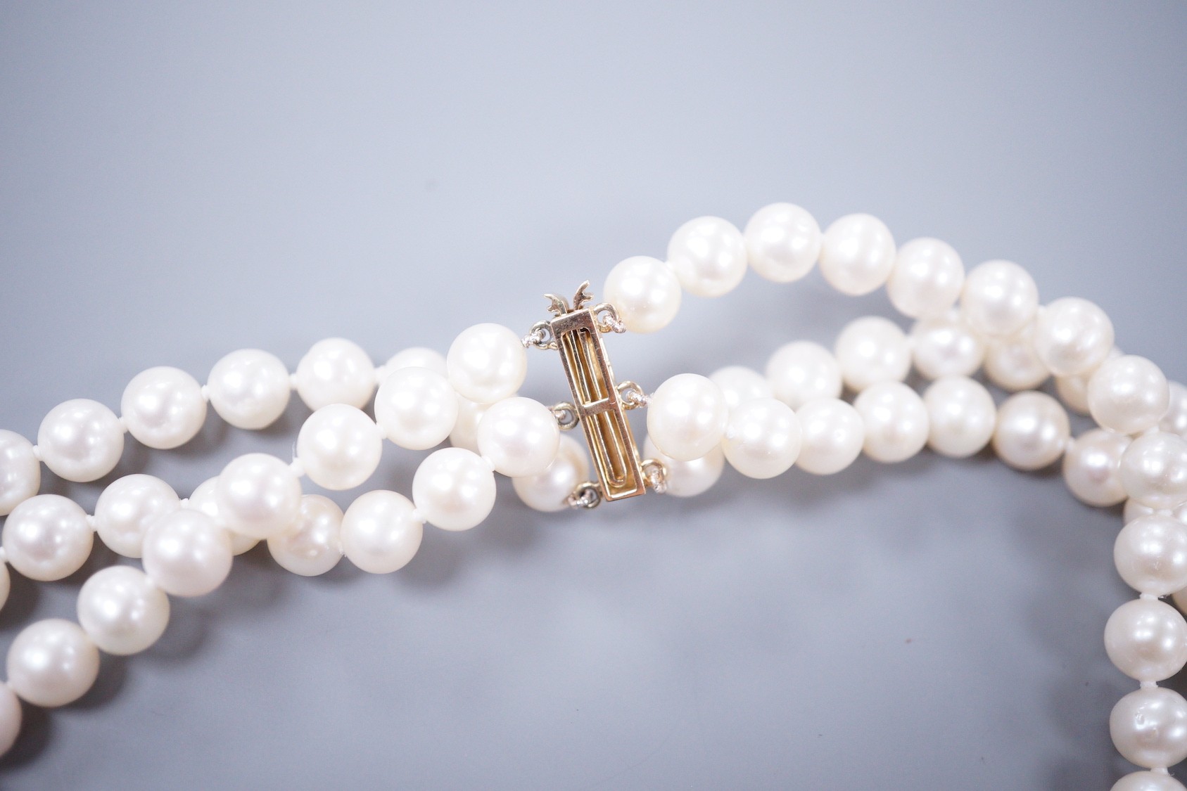 A modern triple strand cultured pearl set choker necklace, with 375 yellow metal clasp, 43cm.